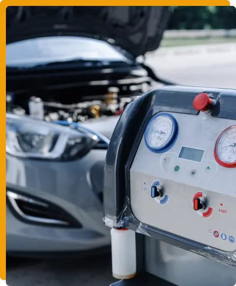 Auto AC Repair In Tomball TX At Jon’s Auto & Diesel Repair. Image of Automotive A/C recharge machine performing air conditioning service on a vehicle with the hood open.